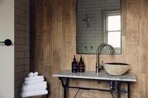 a bathroom with a sink and a mirror at Links House in Bowral