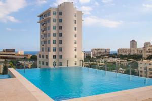 a large swimming pool in front of a tall building at Brand New Luxury Home in Santo Domingo
