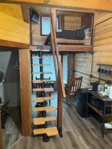 a loft bed in a cabin with a wine cellar at Limestone Lodge in Sabetha