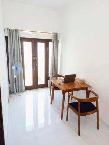 een bureau en stoel met een laptop op een kamer bij Mini tropical home with office in Krambitan