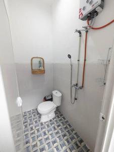 een kleine badkamer met een toilet en een spiegel bij Mini tropical home with office in Krambitan