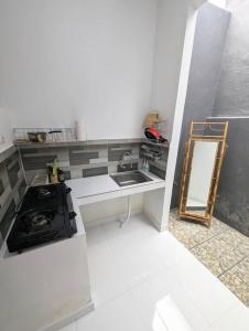 een keuken met een fornuis, een wastafel en een spiegel bij Mini tropical home with office in Krambitan