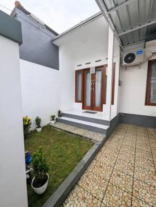 una casa blanca con un patio con plantas. en Mini tropical home with office, en Krambitan