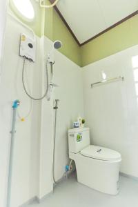 een witte badkamer met een douche en een toilet bij Chommuang Guest House in Phra Nakhon Si Ayutthaya