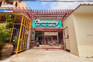 una entrada a un edificio con un cartel en él en Chommuang Guest House, en Phra Nakhon Si Ayutthaya