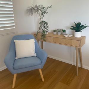 a blue chair sitting next to a desk with plants at Cabarita Beachfront Apartments by Kingscliff Accommodation in Cabarita Beach