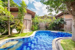 a swimming pool in the yard of a house at Pachamama Canggu Bali in Canggu