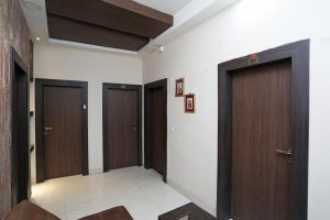 a hallway with three wooden doors in a building at Hotel South Fern in Ballygunge