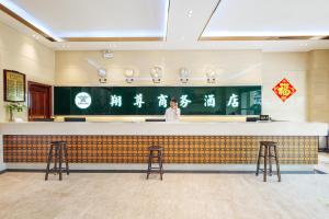een man achter een bar in een restaurant bij Xiamen Xiangzun Hotel - Huijing Plaza Branch in Xiamen