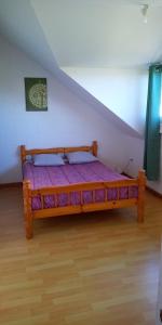 ein Schlafzimmer mit einem Holzbett im Dachgeschoss in der Unterkunft Le Tranquillou in La Plaine des Cafres