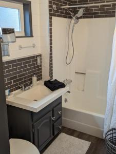 y baño con lavabo, bañera y ducha. en Red Barn Retreat, en North Fork