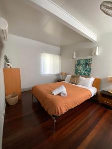 a bedroom with a large bed with an orange blanket at Allure Stradbroke Resort in Point Lookout +87 photos
