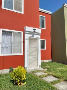 una casa roja con una puerta blanca delante de ella en Casa Mía, en Piura