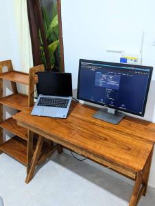 einen Schreibtisch mit einem Computer und einem Laptop darauf in der Unterkunft Tropical oasis private home in Krambitan
