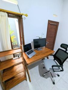 einen Schreibtisch mit einem Laptop und einem Computer darauf in der Unterkunft Tropical oasis private home in Krambitan