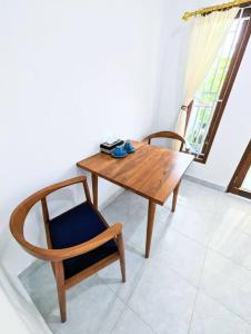 a wooden table and chair in a room with a window at Tropical oasis private home in Krambitan