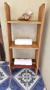 a wooden shelf with two towels on top of a floor at Monkey House Hostel in Tola