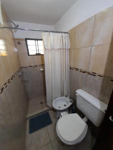 uma pequena casa de banho com WC e chuveiro em cabaña alma dorada em Huerta Grande