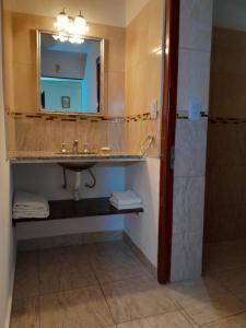 uma casa de banho com um lavatório e um espelho em cabaña alma dorada em Huerta Grande