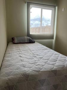 ein großes Bett in einem Zimmer mit Fenster in der Unterkunft Casa Nueva 3 dormitorios 2B in Puerto Montt