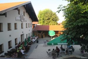 un groupe de personnes assis à l'extérieur d'un bâtiment dans l'établissement Gasthaus Murauer, à Simbach am Inn