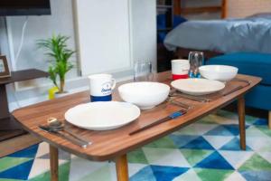 einem Holztisch mit Platten und Schalen darauf in der Unterkunft Yoyogi Apartment 1-401 in Tokio