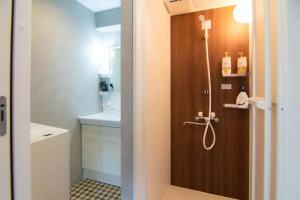 a bathroom with a shower with a wooden door at Yoyogi Apartment 1-401 in Tokyo