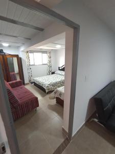 a bedroom with a bed and a couch and a chair at Apartamento Central in Ibagué