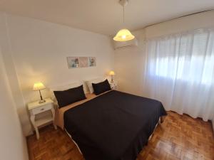 a bedroom with a black bed and a window at Departamento con excelente ubicación en Córdoba, Argentina in Cordoba