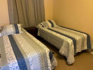 dos camas sentadas una al lado de la otra en una habitación en Departamento Frente al Mar, Playa Bellavista, Tome, en Tomé