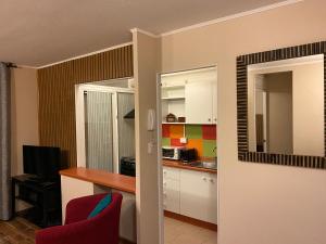 a kitchen with a desk and a red chair in a room at Departamento Frente al Mar, Playa Bellavista, Tome in Tomé