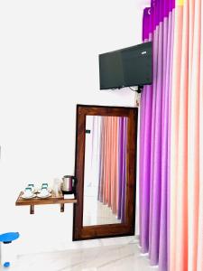 einen Spiegel in einem Zimmer mit lila Vorhängen in der Unterkunft Ella Tea Heaven Villa in Ella