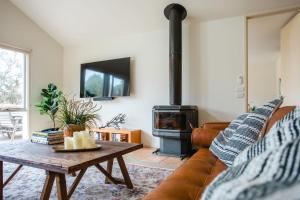 sala de estar con sofá y estufa de leña en Baringa House, en Shoreham