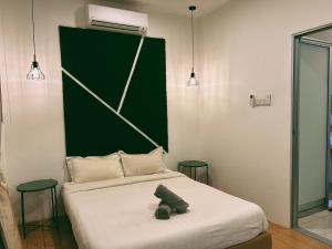 a bedroom with a bed with a green headboard at Stylish 2 Bedroom Apartment by Thirteen Residence at ITCC Manhattan suites TR09 in Donggongon