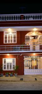 un edificio rojo con ventanas blancas y balcón en Villa Dumont en Pondicherry