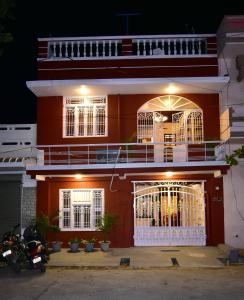 a red building with a balcony on top of it at Villa Dumont in Puducherry