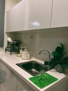 um lavatório de cozinha com uma esponja verde em Stylish 2 Bedroom Apartment by Thirteen Residence at ITCC Manhattan suites TR09 em Donggongon