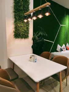 a white table and chairs in a room with a green wall at Stylish 2 Bedroom Apartment by Thirteen Residence at ITCC Manhattan suites TR09 in Donggongon