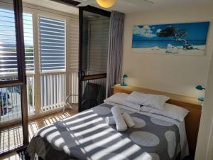 a bedroom with a bed and a large window at Gemini Unit 64 Golden Beach QLD in Golden Beach +8 photos