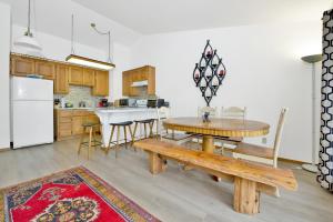 a kitchen and dining room with a wooden table and bench at 2341-Bear Meadow Woods Condo condo in Big Bear Lake