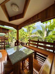 a balcony with a table and a view of the jungle at MAGMAI HOMESTAY & TOWER in Tak