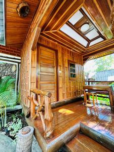 a porch of a wooden cabin with a bench at MAGMAI HOMESTAY & TOWER in Tak