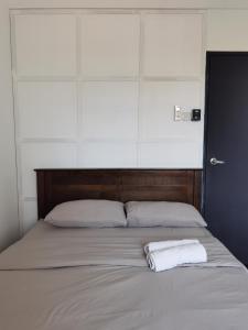 a bed with a white towel on top of it at Apartment in Ladang Tok Pelam - Hana Home by the Sea in Kuala Terengganu