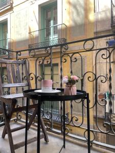a table and a chair on a balcony with a cake at Private Room Gothic Quarter in Barcelona