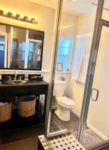 a bathroom with a toilet and a sink and a mirror at Hollywood house with parking - walk to attractions in Los Angeles