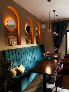 a living room with a green couch and tables at AVIOR Garni Hotel in Subotica