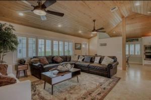 a living room with a leather couch and a table at Relaxing 2 2 Get Away in the Lower Keys! home in Summerland Key