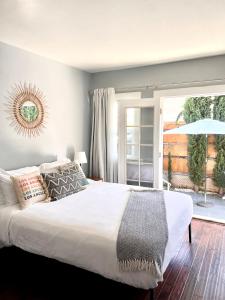 a bedroom with a large white bed and a window at Hollywood house with parking - walk to attractions in Los Angeles