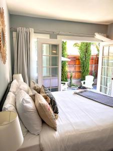 a bedroom with a large white bed with pillows at Hollywood house with parking - walk to attractions in Los Angeles