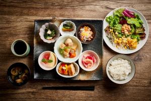 Daiwa Roynet Hotel Nara Natural Hot Spring في نارا: طاولة مع أطباق من الطعام وأوعية من الأرز